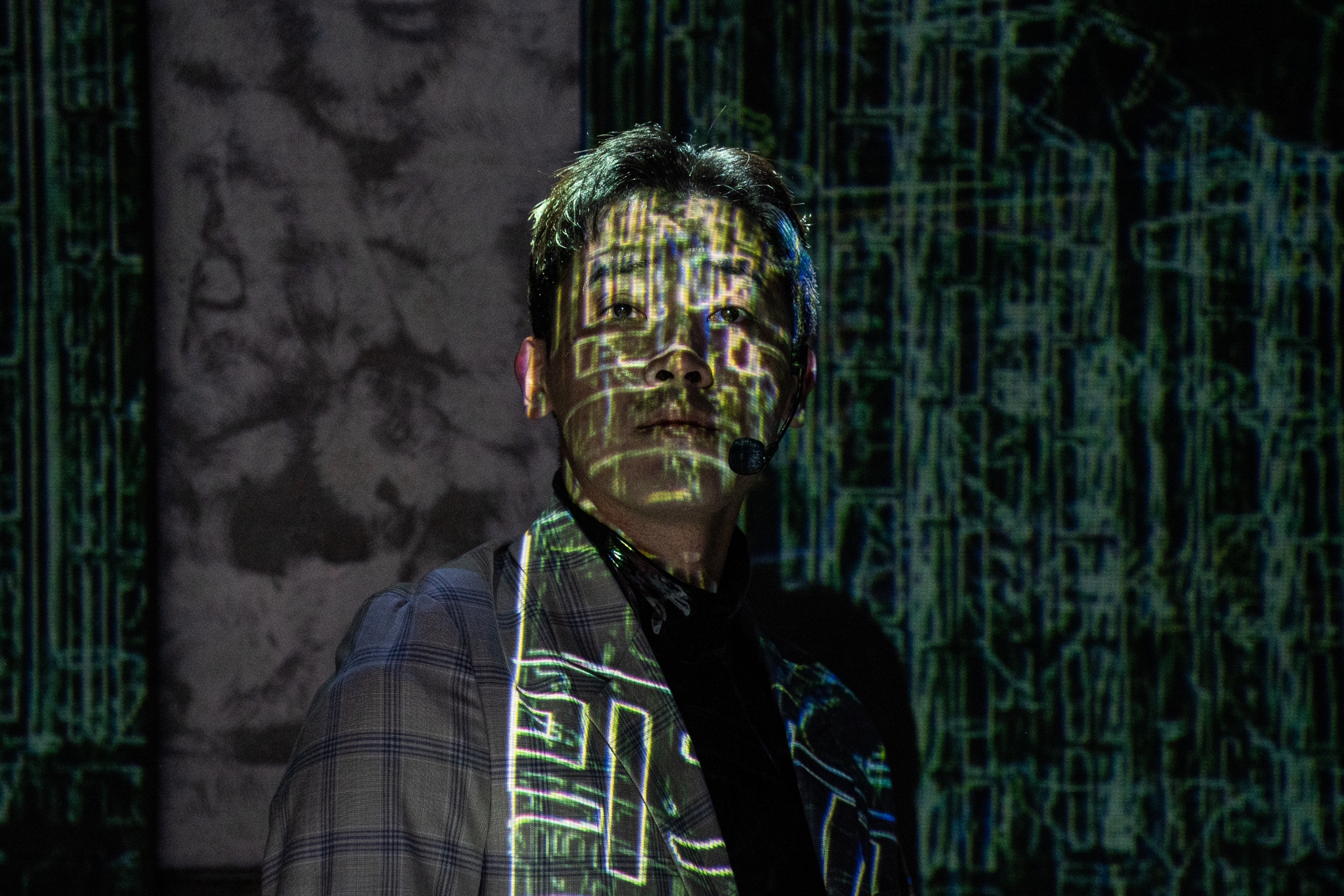 한 남성의 얼굴에 녹색의 복잡한 디지털 회로 패턴이 투사된 모습