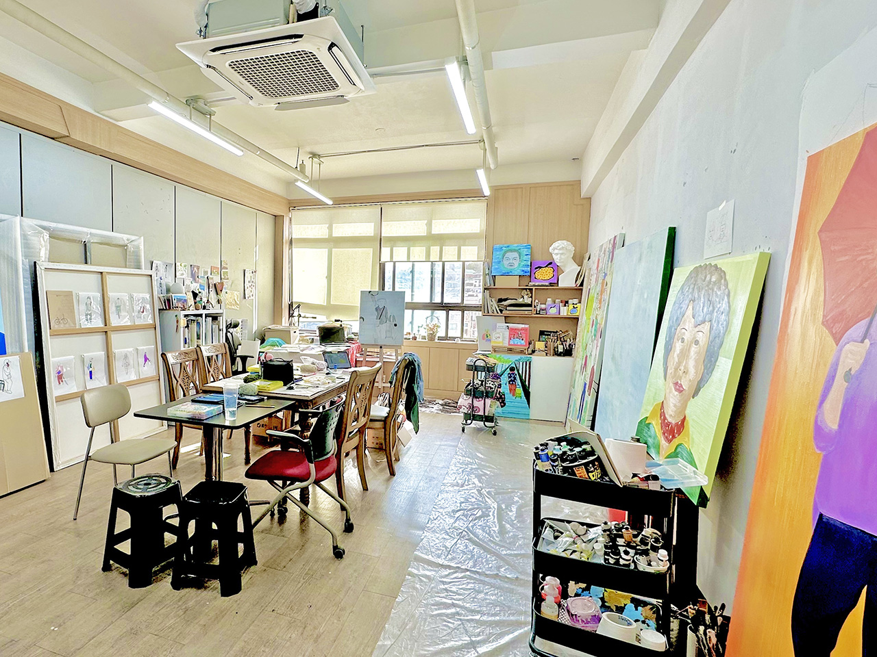 이젤과 미술 도구, 작품들이 놓여있는 화가의 작업실