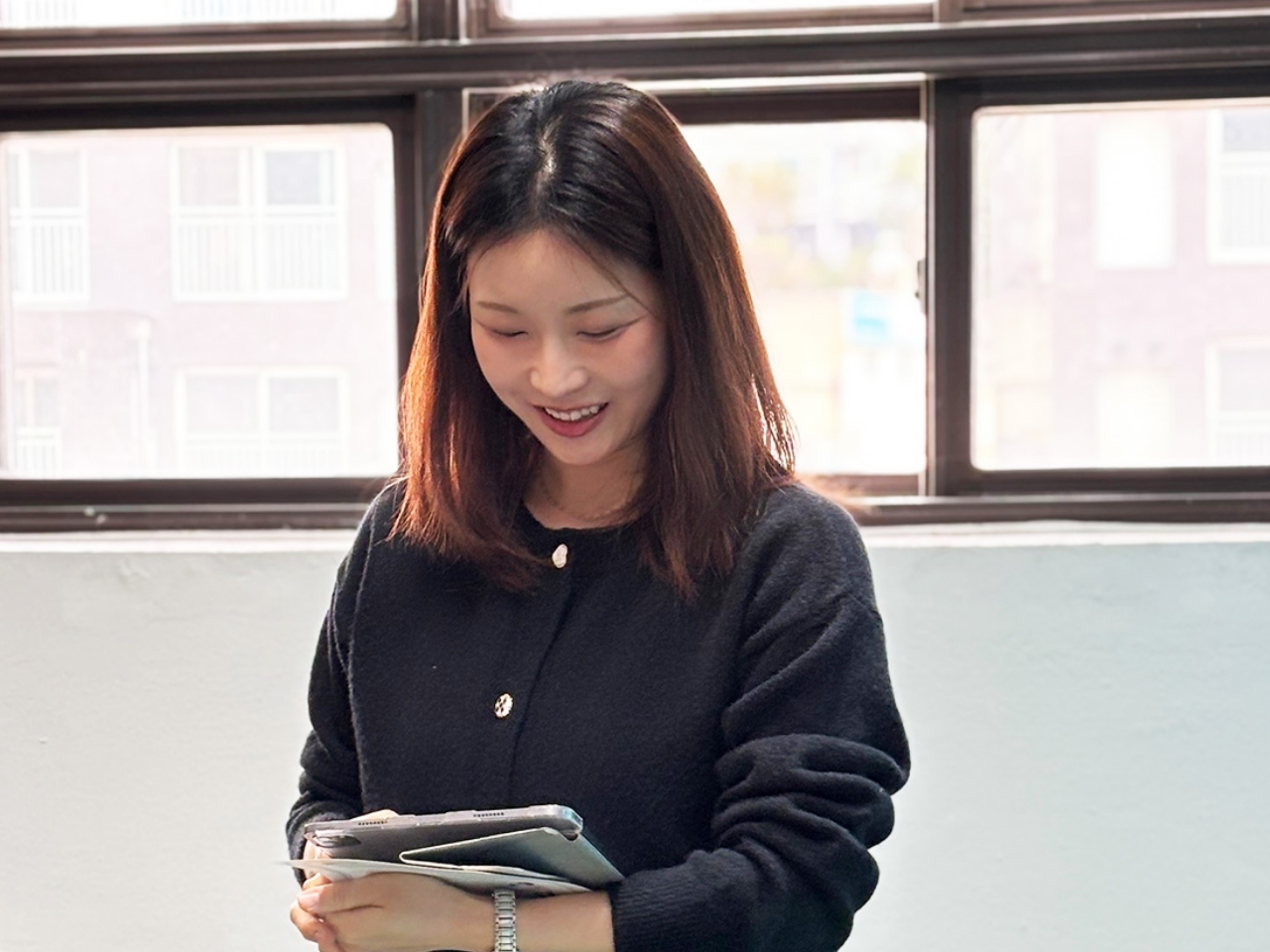 자신의 작품을 들고 미소 짓고 있는 여성 작가